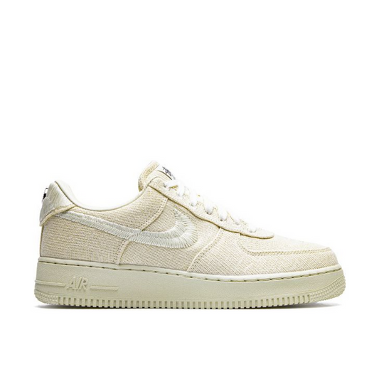 "Nike x Stüssy Air Force 1 Low Fossil sneaker with hemp upper and embroidered Swoosh"

"Side view of Nike x Stüssy Air Force 1 Low Fossil with metallic emblem badges and natural tones"

"Close-up of Nike x Stüssy Air Force 1 Low Fossil showing Stüssy branding on tongue and heel"

"Nike x Stüssy Air Force 1 Low Fossil – sustainable streetwear collaboration sneaker"