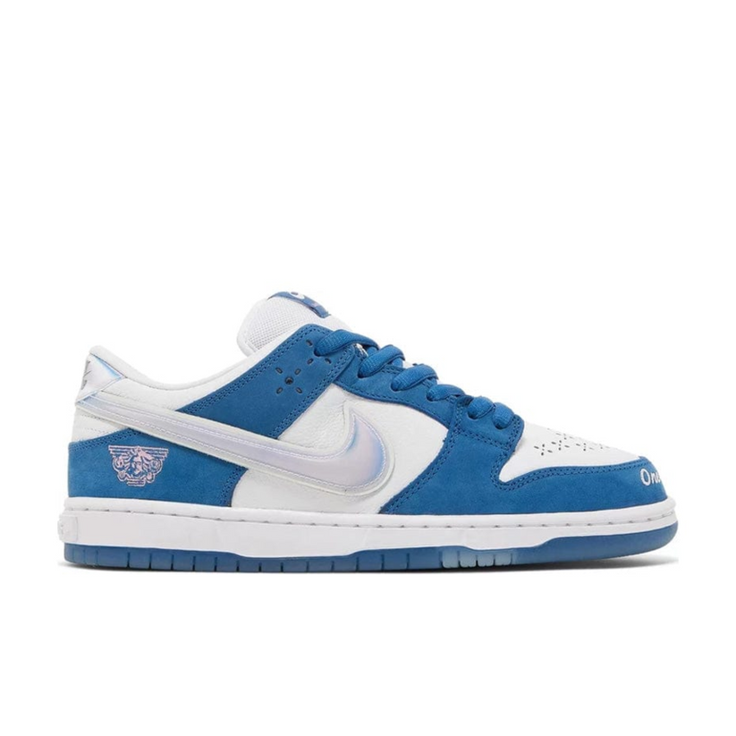 "Nike SB Dunk Low Born x Raised sneaker with white leather and deep royal blue nubuck overlays"

"Side view of Nike SB Dunk Low Born x Raised with holographic Swoosh and perforated toe box"

"Close-up of Nike SB Dunk Low Born x Raised showing embroidered text and heat-pressed laces"

"Nike SB Dunk Low Born x Raised – cultural tribute sneaker with premium materials and unique details"